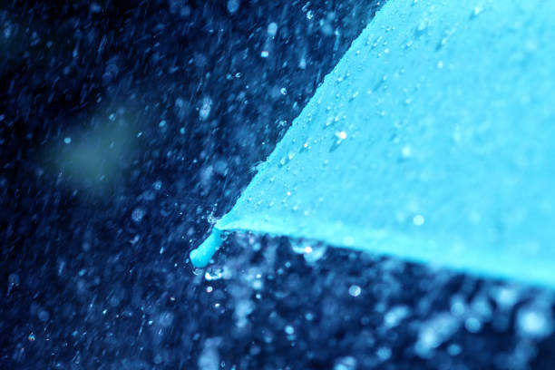 istock selective focus for close up a part of umbrella which has Rain drops falling , shallow DOF 683647088