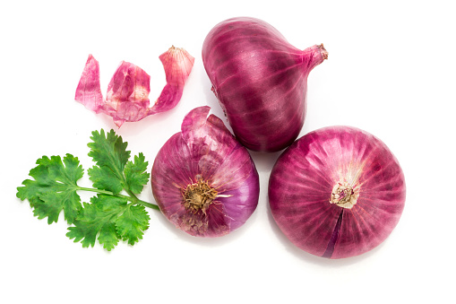 Fresh red onion sliced bulb and onion peel isolated on white background