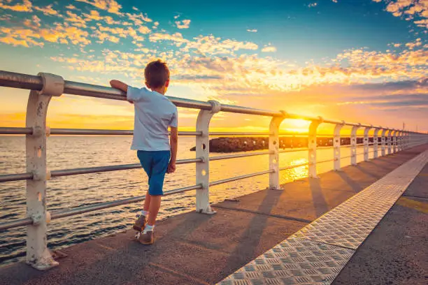 Photo of Boy watching sunset from St. Kilda Jetty