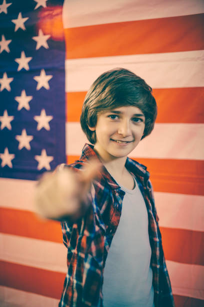 um rapaz na frente da bandeira americana - child flag patriotism thumbs up - fotografias e filmes do acervo