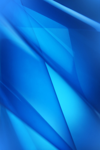Blue abstract background with random shapes, shadows and highlights shot with selective focus to allow copy space on defocused areas