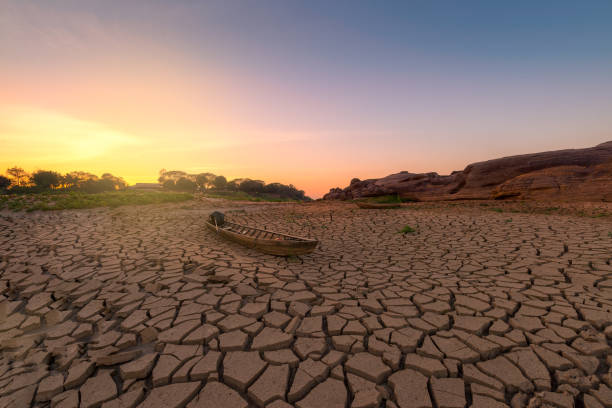 Wooden boat on drought land with sunrise