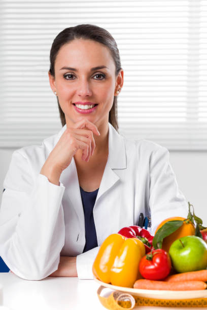 istock Female dietician showing vegetables and fruit 683653432