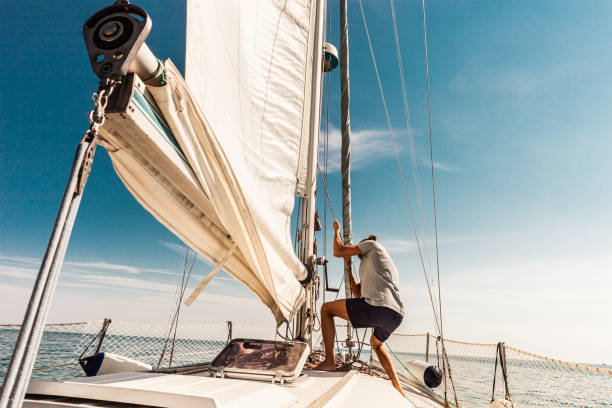 uomo che naviga e pesca durante le vacanze estive - barca a vela foto e immagini stock