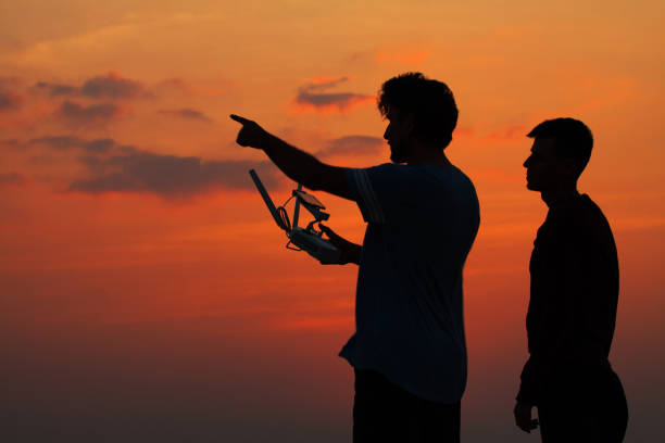 istock Silhouette of two man operating drone 683660448