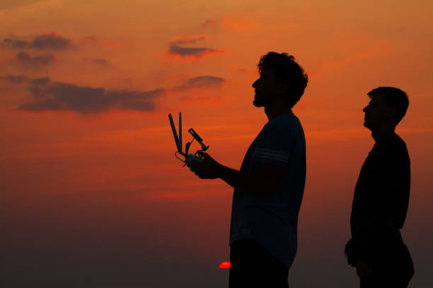 istock Silhouette of two man operating drone 683660454