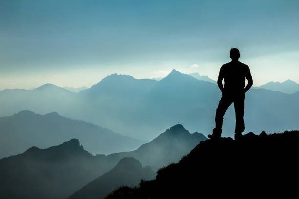 istock Man watching dreamfully towards spectacular mountain range silhouettes. 683671458