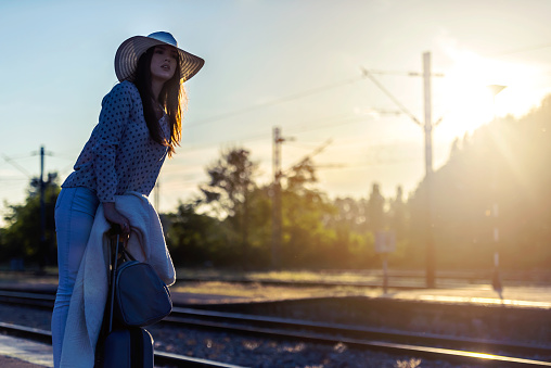 Young woman with luggage on train station