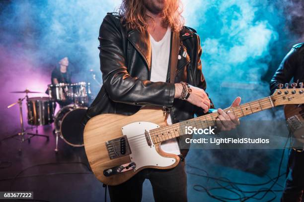 Photo libre de droit de Tir Cultivé Du Joueur Électrique De Guitare Jouant La Musique De Hard Rock Sur Létape banque d'images et plus d'images libres de droit de Groupe de rock