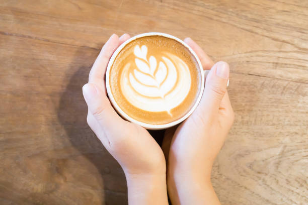 istock Cup of latte art coffee holding by hand 683678064
