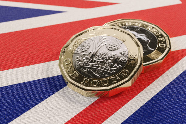 dois 2017 libra moedas descansando sobre uma bandeira britânica. - british flag currency banking uk - fotografias e filmes do acervo