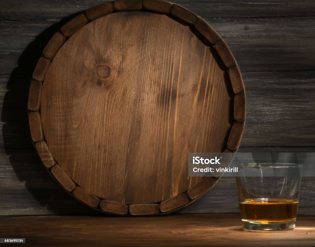 whiskey on a wooden whiskey on a wooden background in the darkness, drawn by light and the barrel Barrel Stock Photo