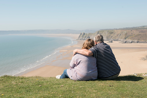 Happy mature couple outdoors over looking a beach landscape view