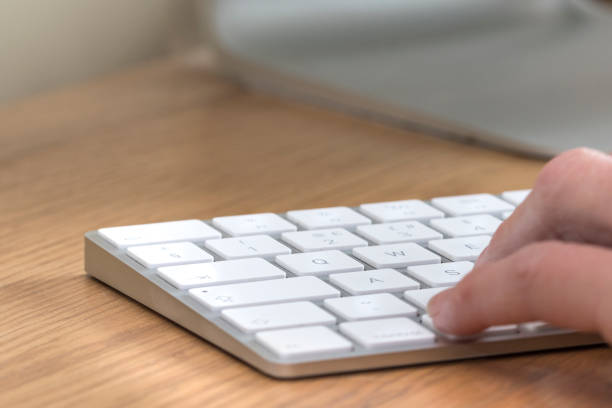 Hand typing on keyboard stock photo