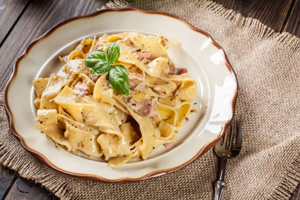 istock Pappardelle pasta with prosciutto and cheese sauce on a plate 683715734