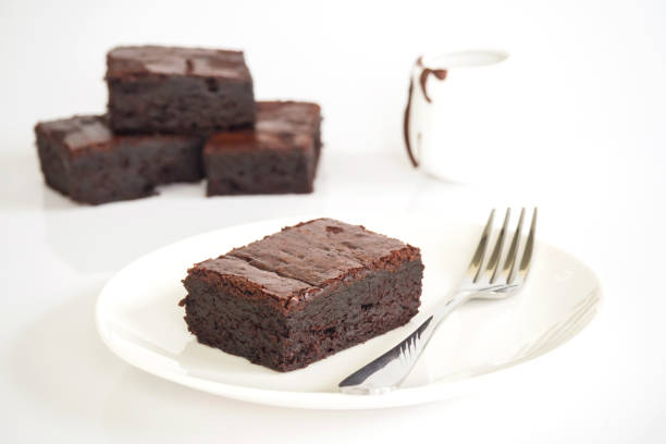 istock Sliced brownies on white plate. Served with chocolate fudge topping. On white plate with fork. 683716028