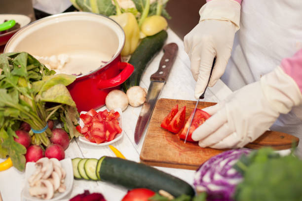 토마토를 절단 하는 장갑과 주부 - food safety 뉴스 사진 이미지