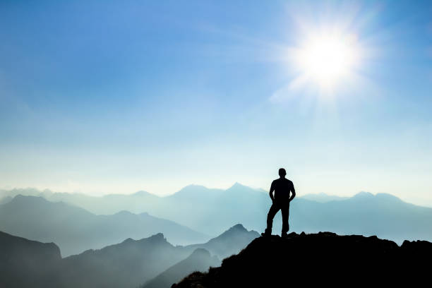 istock Man reaching summit enjoying freedom and watching towards mountain ranges. 683725678