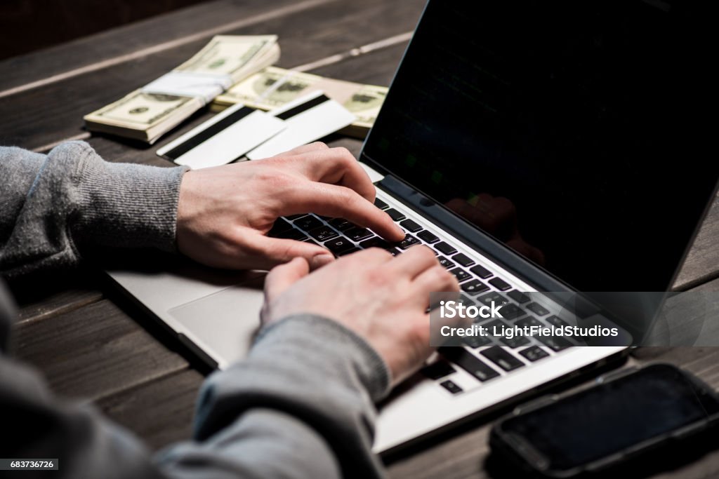 Hacker using laptop Close-up partial view of man typing on laptop with blank screen Adult Stock Photo