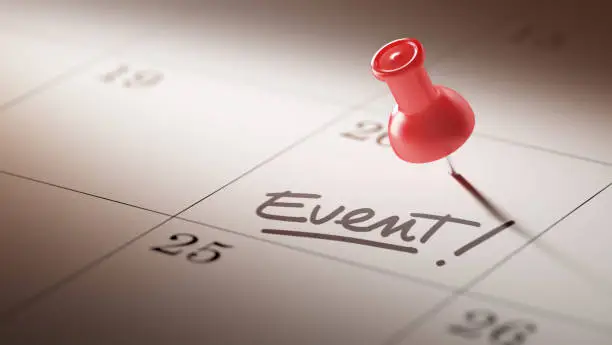 Concept image of a Calendar with a red push pin. Closeup shot of a thumbtack attached. The words Event written on a white notebook to remind you an important appointment.