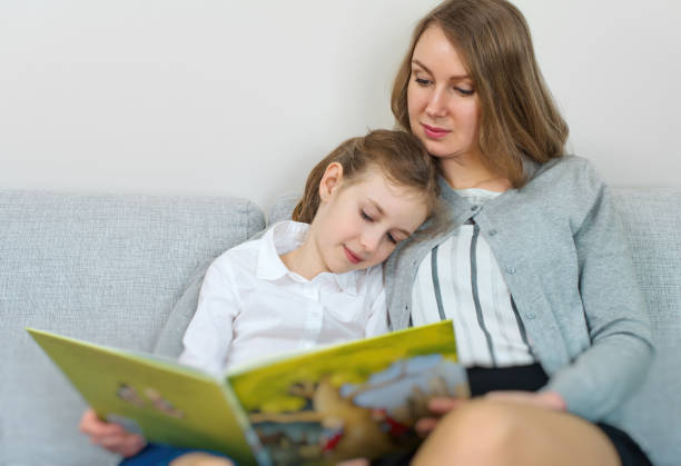 istock Mother and daughter reading a book. 683739954
