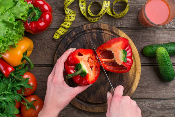 istock Female hands cutting pepper at table, top view 683740522
