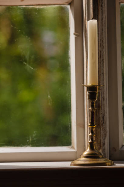 istock Old vintage window and vertical candle in candlestick 683740892