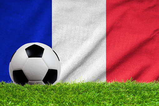 Football on grass field with wave flag of France