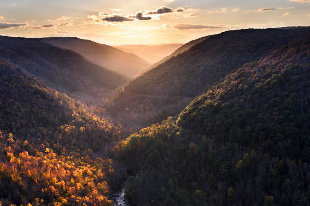 sun lighting mountains in fall colors - valley tree remote landscape imagens e fotografias de stock