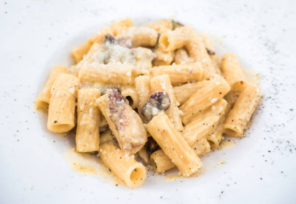 authentic recipe rigatoni spagetti a la carbonara rome roma dish trastevere Authentic rigatoni a la carbonara in a dish rigatoni stock pictures, royalty-free photos & images