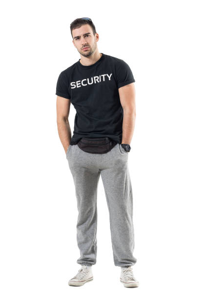 istock Skeptical young bouncer with hands in pockets frowning and looking at camera. 683778198
