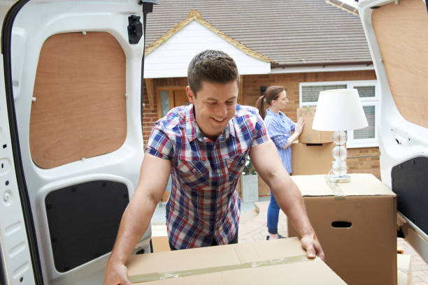 Young Couple Moving In To New Home Unloading Removal Van Young Couple Moving In To New Home Unloading Removal Van moving truck stock pictures, royalty-free photos & images