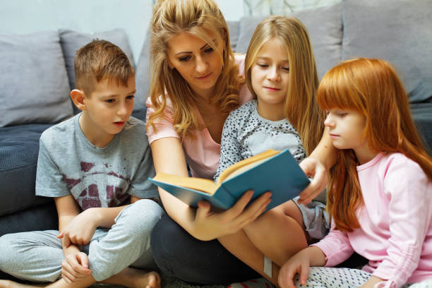 istock Mother reading a book to her children 683793626