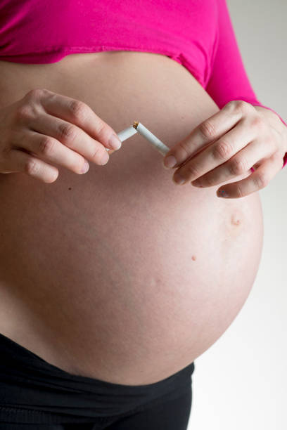istock Pregnant woman breaking a cigarette in half 683796564