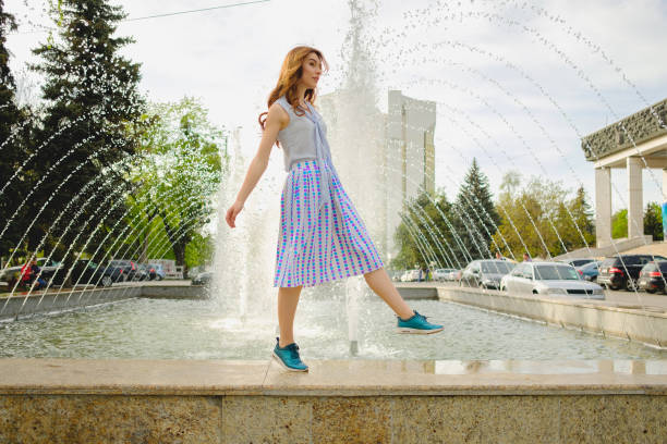 Beautiful brunette young woman wearing skirts and walking on the street in the city