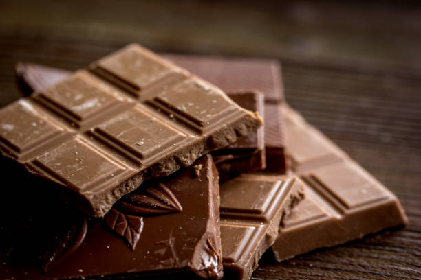 istock black and milk chocolate pieces wooden table background 683802164
