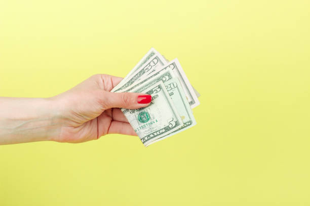 istock American dollars in the woman's hand, yellow background 683805064