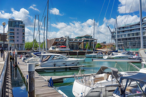 The Norwegian port of Stavanger, Norway, Europe. There are moored sailing ships in the foreground and dockside bars in the background.