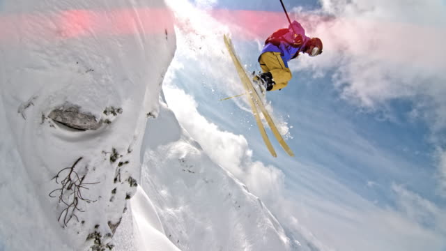 SLO MO Male backcountry skier jumping off a rock