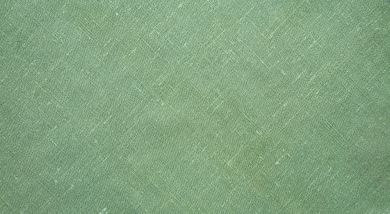 Natural Rough Flax Diagonal weave Fabric, Cloth texture. Pale Green textile Background or Wallpaper, close up. Web banner Wide Horizontal Image With Copy Space