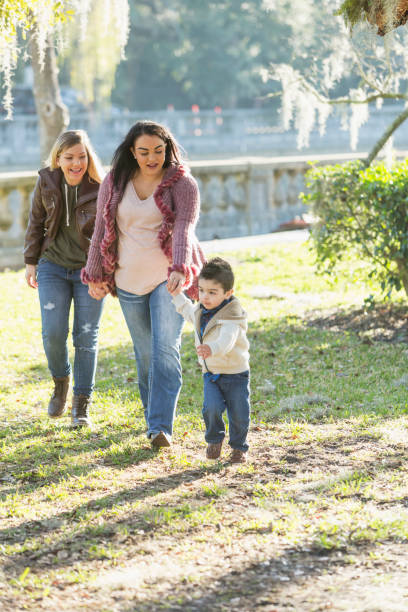 istock Little boy, two mothers walking in park, holding hands 683821068