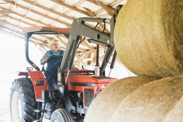 A wide angle view of a farmer getting their big tractor out from the barnon the farm he works at in Northumberland in the North East of England.