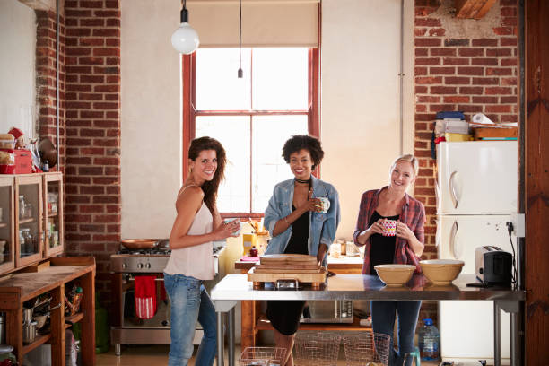 istock Three young adult girlfriends in kitchen look to camera 683841378