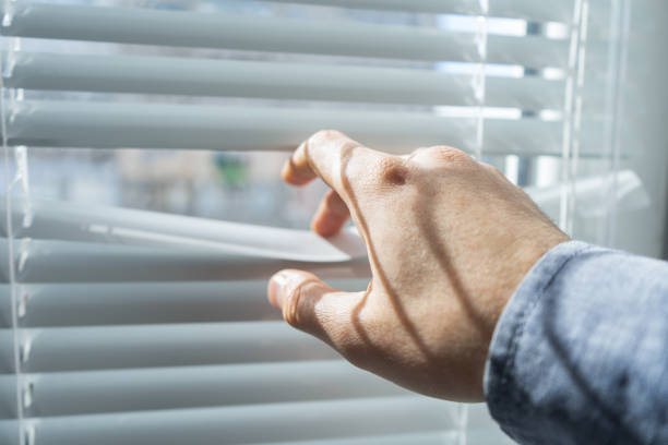 istock Man's hand opens the blinds or jalousie in sunny day. 683848822