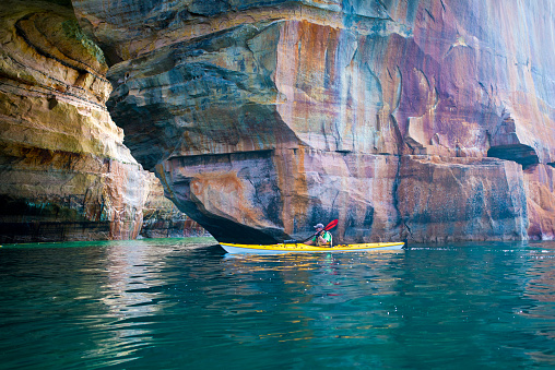 Sea kayaker paddling around a stone arch at the Pictured Rocks National Lakeshore on Lake Superior in Michigan’s Upper Peninsula