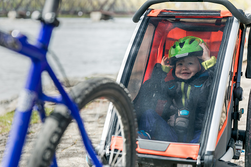 Cute Toddler Baby Boy inside Baby Stroller attached behind a mountain bike