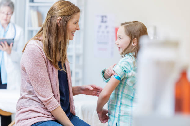 istock Mom comforts daughter after receiving vaccination 683866442