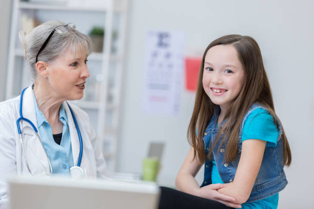 istock Senior female pediatrician talks with young patient 683866470