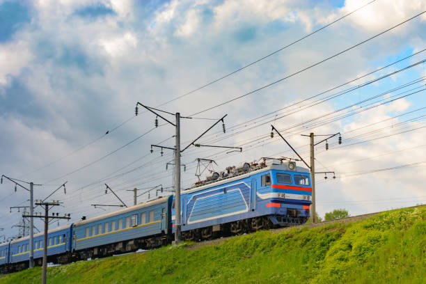 istock Passenger train rides on an electrified line against a blue sky 683867442