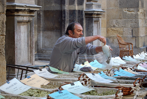 Street vendor selling herbs and spices at the walls of the Cathedral of the Incarnation - Granada, Andalucia, Spain